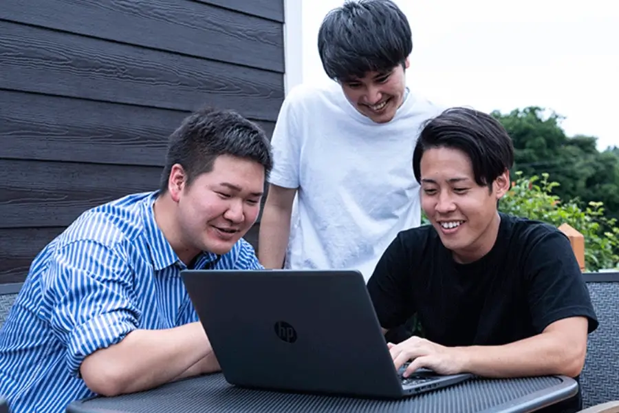 パソコンを使う3人の男性 写真